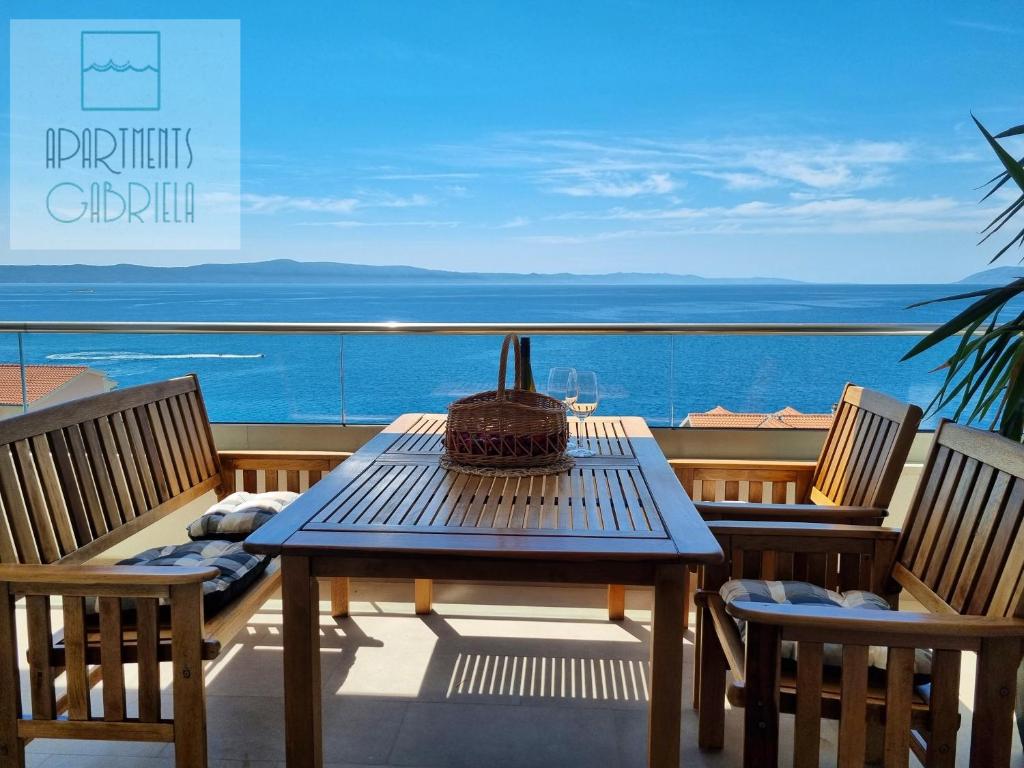 uma mesa e cadeiras numa varanda com vista para o oceano em Apartments Gabriela em Drasnice