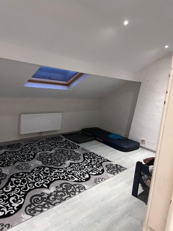 a attic room with a bed and a skylight at Grande maison avec plusieurs chambres à louer in Liège