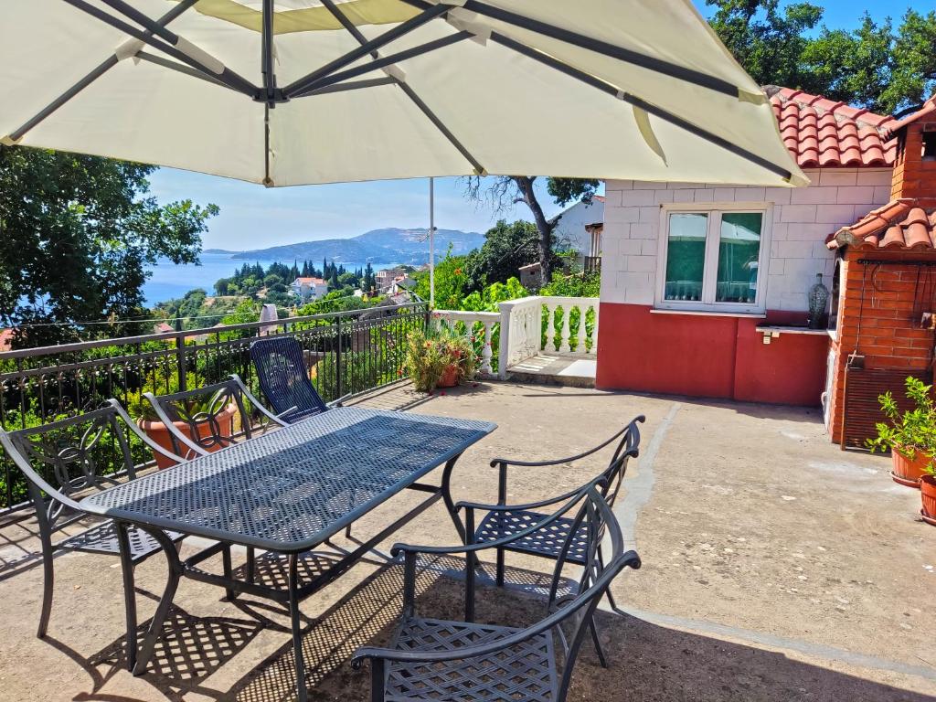 a table and chairs under an umbrella on a patio at Dubrovnik Moonshine Apartment in Mlini