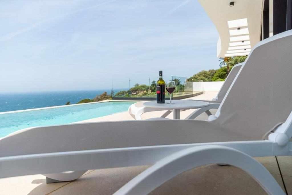 a bottle of wine sitting on a table next to a pool at Villa El Buzo in Zahara de los Atunes