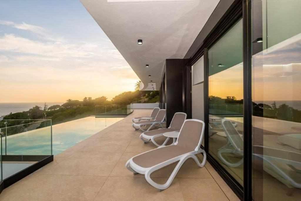 a row of chairs sitting on a balcony at Villa El Buzo in Zahara de los Atunes