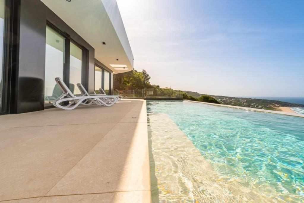 a house with a swimming pool next to the ocean at Villa El Buzo in Zahara de los Atunes