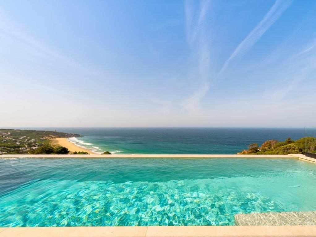 a swimming pool with a view of the ocean at Villa El Buzo in Zahara de los Atunes