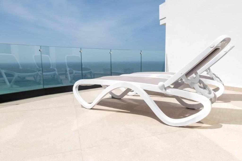 a white chair sitting in front of a window at Villa El Buzo in Zahara de los Atunes