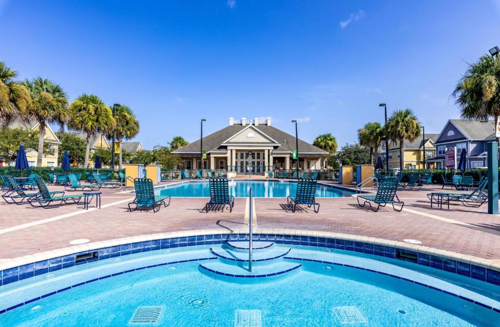 a swimming pool with chairs and a resort at Villas at Seven Dwarfs Resort - Near to Disney in Kissimmee