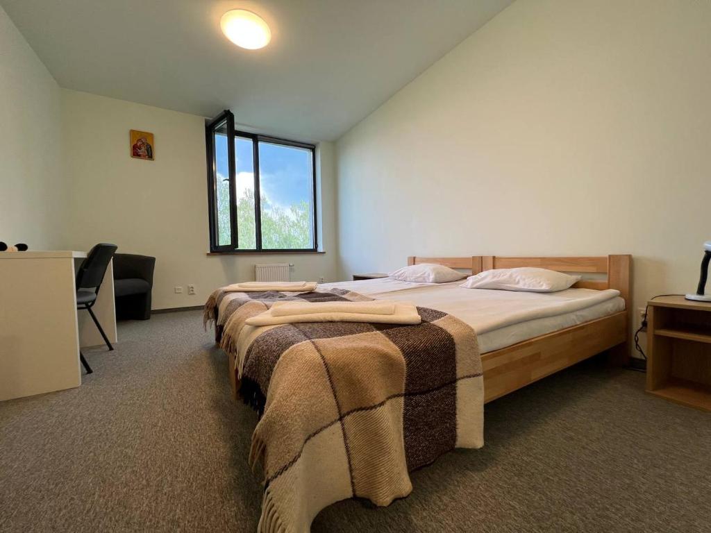 1 dormitorio con 2 camas y ventana en UCU INN - Кімнати для гостей en Leópolis