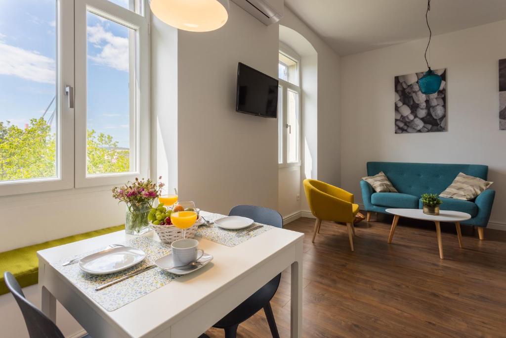 een woonkamer met een tafel en een bank bij BU2 Pula Studio Apartment in Pula