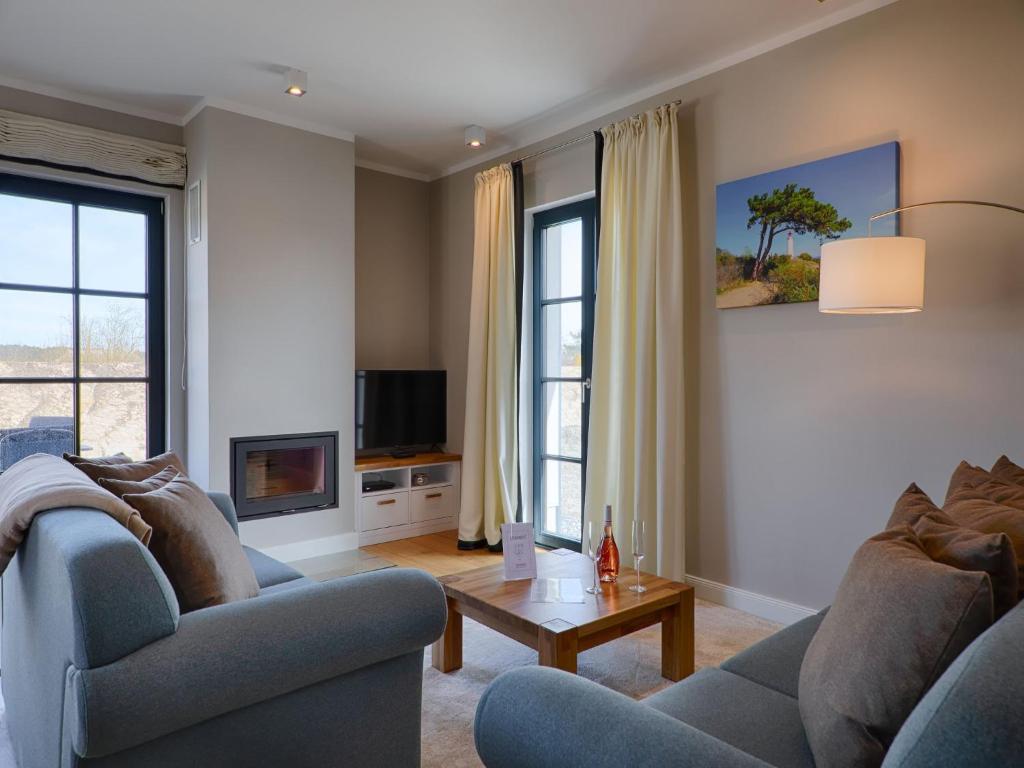 a living room with two couches and a tv at Reetland am Meer - Premium Reetdachvilla mit 3 Schlafzimmern, Sauna und Kamin F26 in Dranske