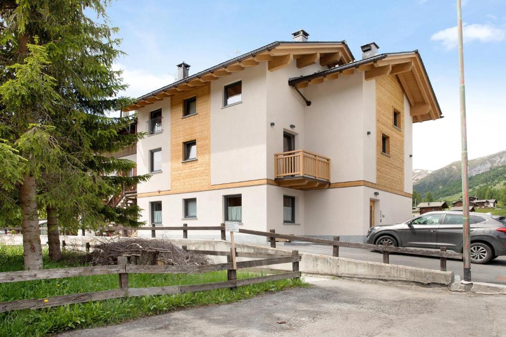 budynek z zaparkowanym przed nim samochodem w obiekcie Appartamento Lago Casa Campacc w Livigno