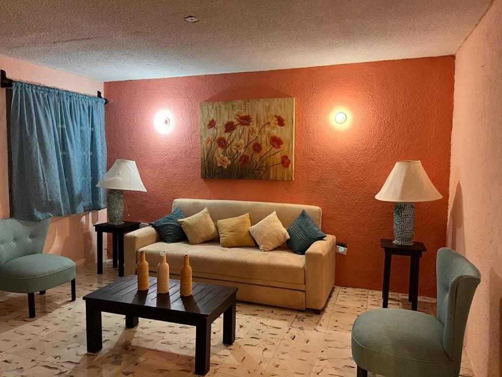 a living room with a couch and two chairs at Casa Estelar in Cancún