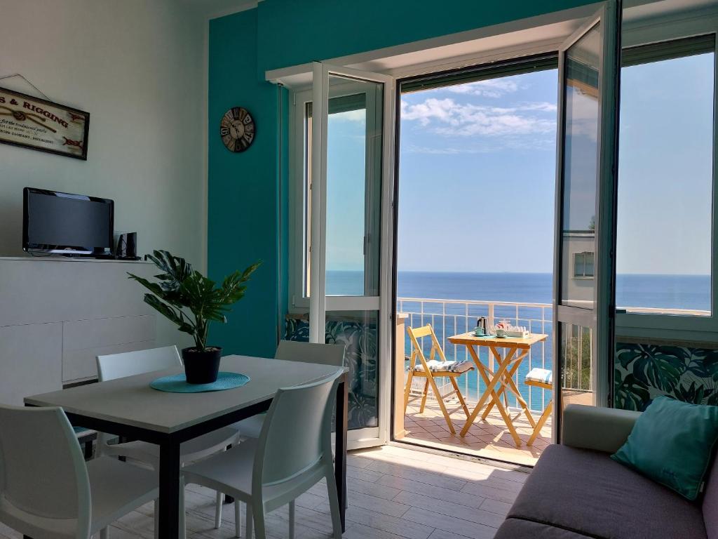 uma sala de estar com uma mesa e vista para o oceano em Una finestra sul mare Home 1 em Bergeggi