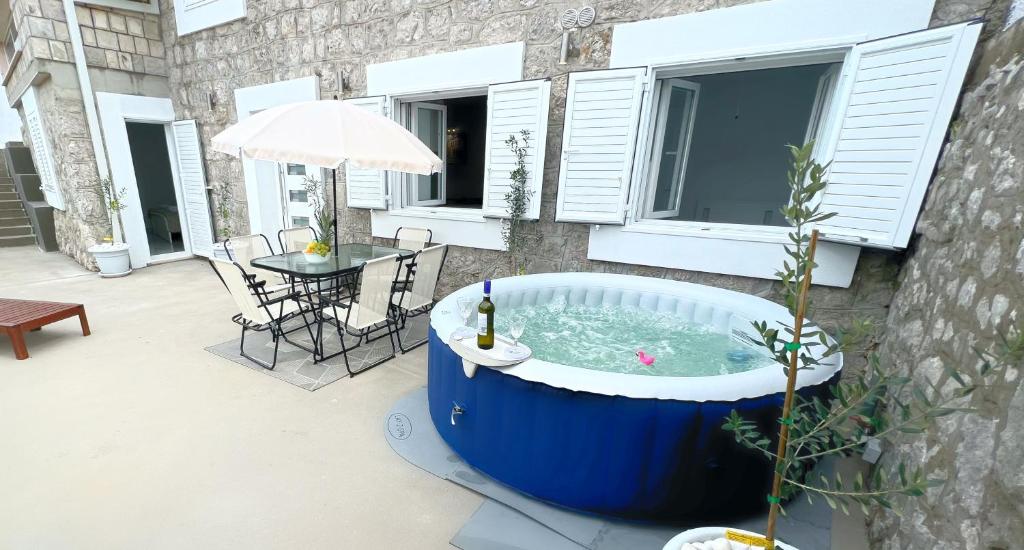 a jacuzzi tub on a patio with a table at Apartman Laura in Mlini