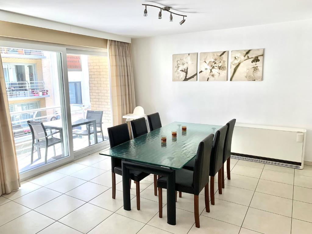 uma sala de jantar com uma mesa verde e cadeiras em Vakantieappartement Sauvignon Centrum Oostende em Oostende