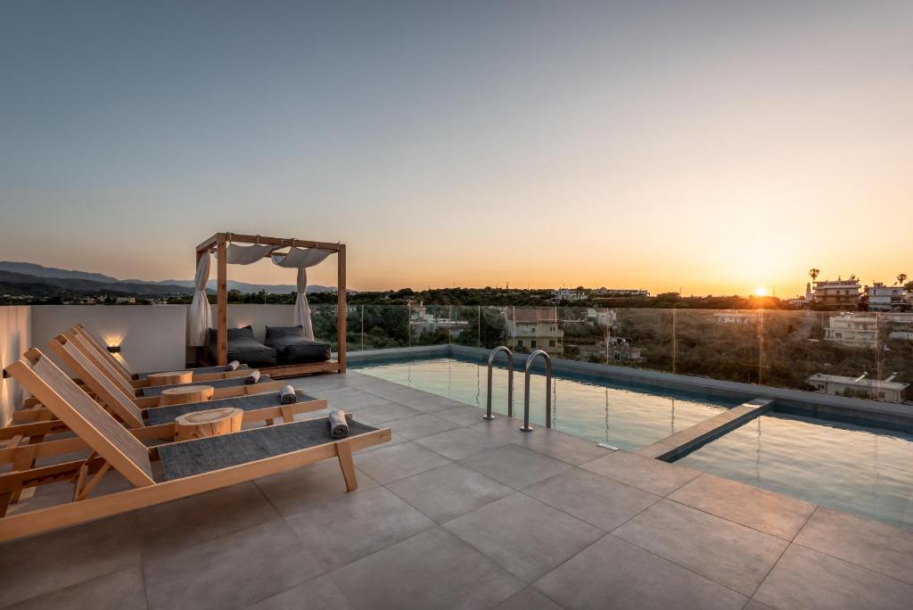 a rooftop pool with benches and a view of the city at Soleado Villa Chania (rooftop pool) in Chania Town