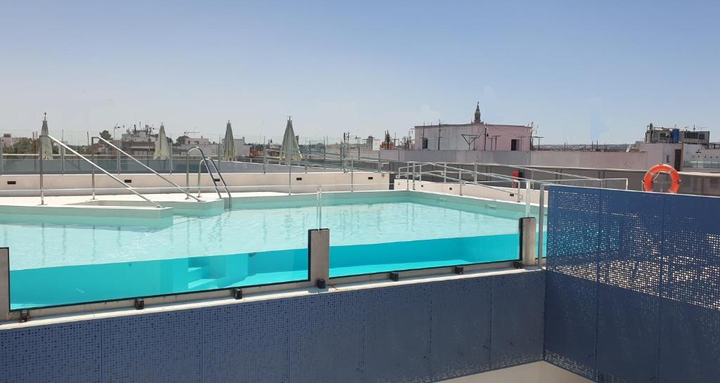a swimming pool with blue walls and a blue sky at Hotel Macià Sevilla Kubb in Seville