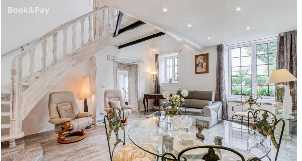 a living room with a staircase and a glass table at Harmonia maison de caractère proche PROVINS in Gouaix