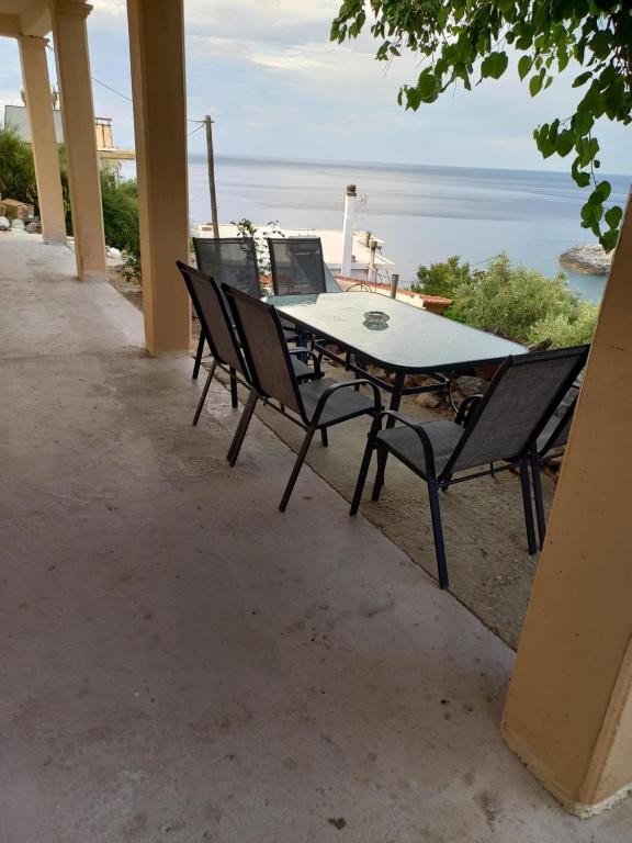 a table and chairs on a patio overlooking the ocean at Stellas apartment in Évdhilos