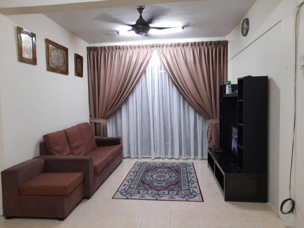 ein Wohnzimmer mit einem Sofa und einem TV in der Unterkunft Dhuha Homestay @ Seri Alam Masai , Johor in Masai