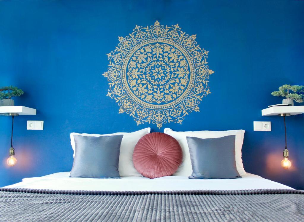 Dormitorio azul con cama con almohada rosa en SUNSET ART Beach Front en Chernomorets