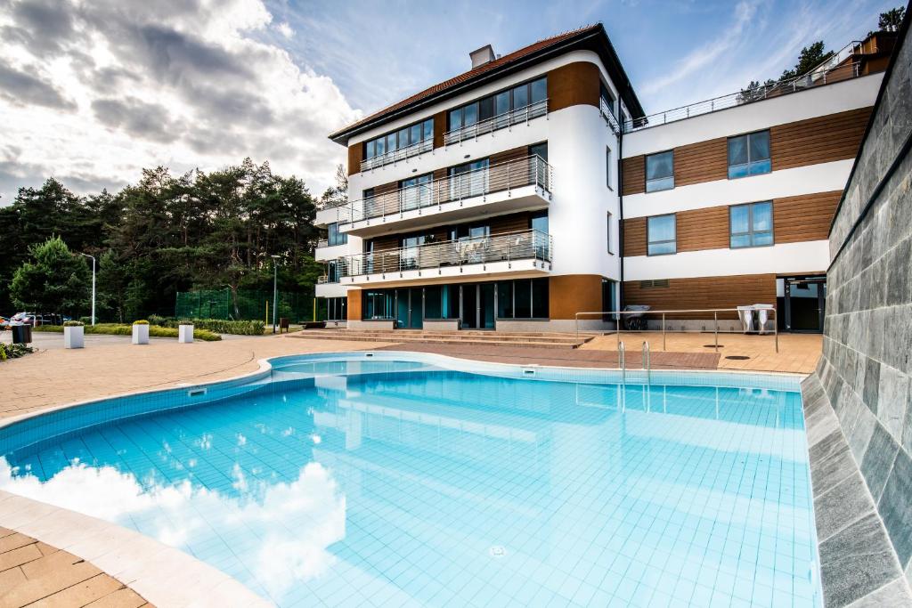 a large swimming pool in front of a building at Baltica Heaven by 2HomeRent - przestronne apartamenty premium przy samej plaży in Rogowo