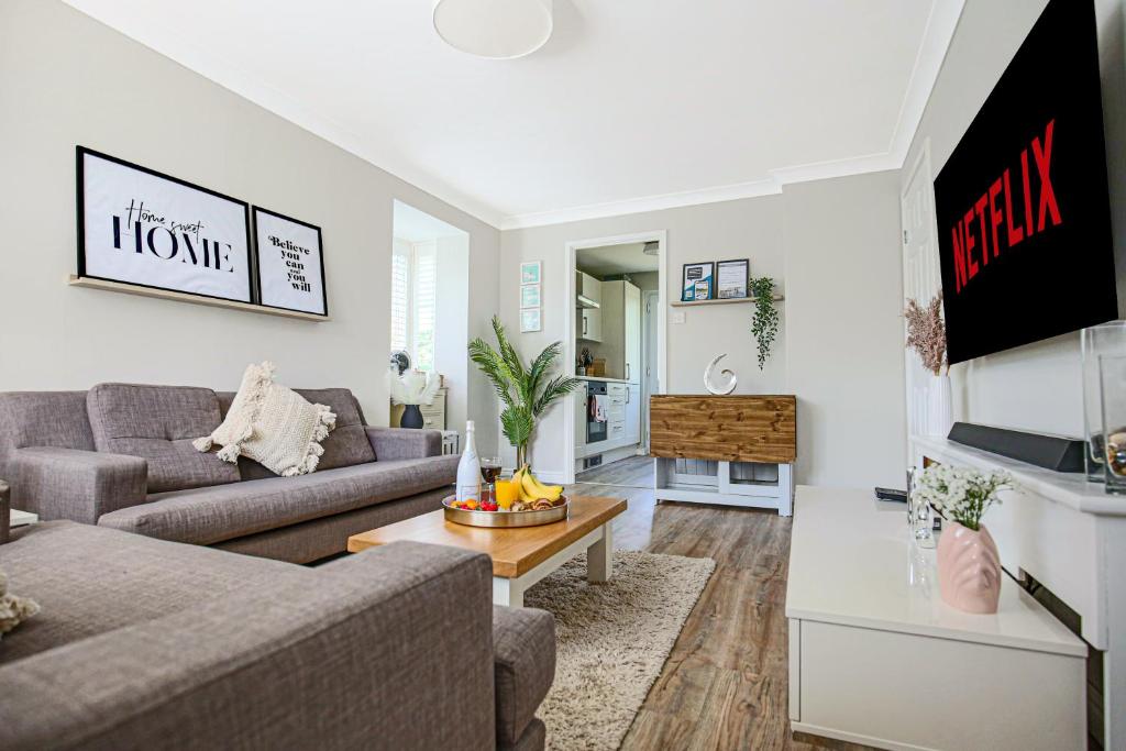 uma sala de estar com um sofá e uma mesa em Lowndes House - Close to City Centre - Garden, Free Parking and Smart TV by Yoko Property em Milton Keynes