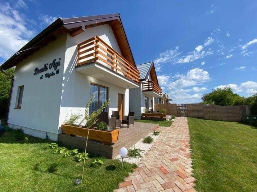 una pequeña casa blanca con un patio de césped en Domki Agi en Jastrzębia Góra
