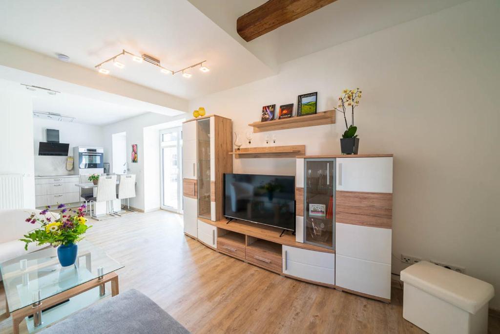 a living room with a large entertainment center with a flat screen tv at Ferienhaus Teichblick und Turmblick, mit Kultur in Großzschepa, Nähe Leipzig in Großzschepa