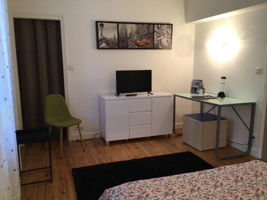 - une chambre avec un bureau, une télévision et un lit dans l'établissement Le Clos Domenat 4, à Brive-la-Gaillarde