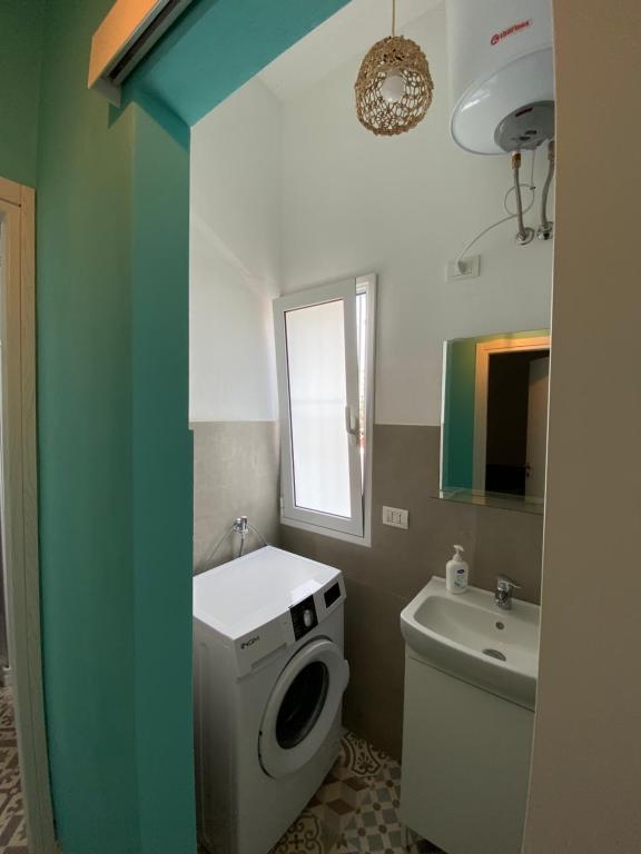 ein Badezimmer mit einer Waschmaschine und einem Waschbecken in der Unterkunft Casa Vacanze , Scoglitti in Scoglitti