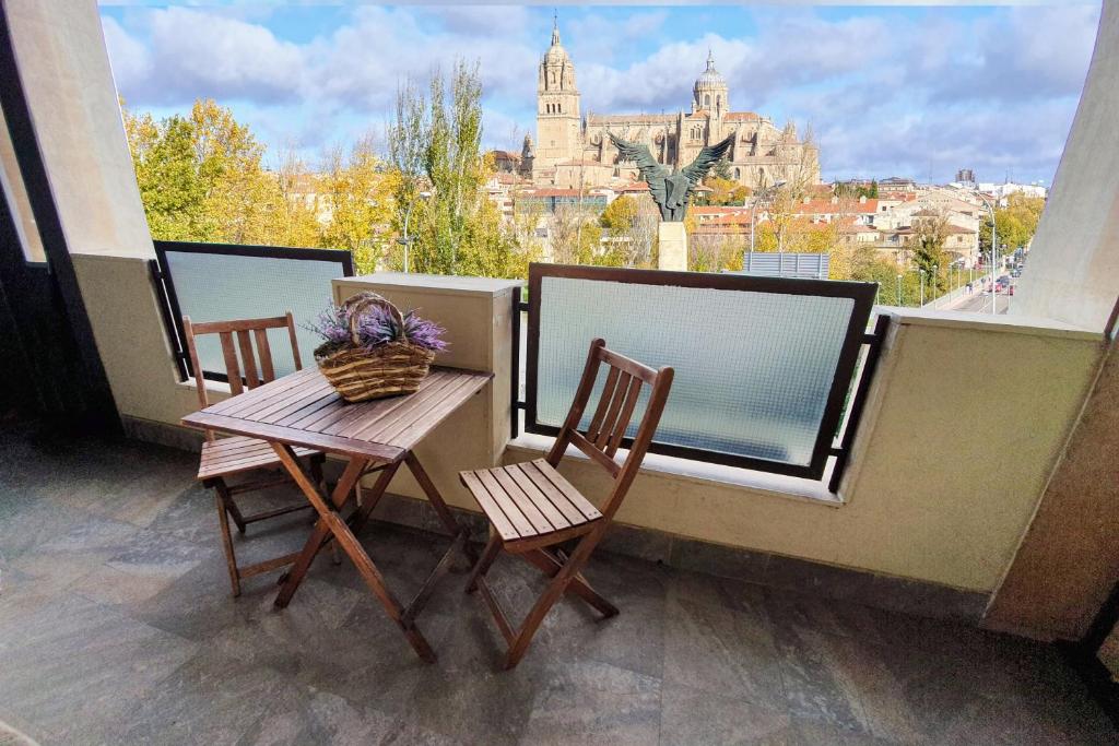 uma varanda com 2 cadeiras, uma mesa e uma janela em Las Mejores VISTAS de SALAMANCA!!! em Salamanca