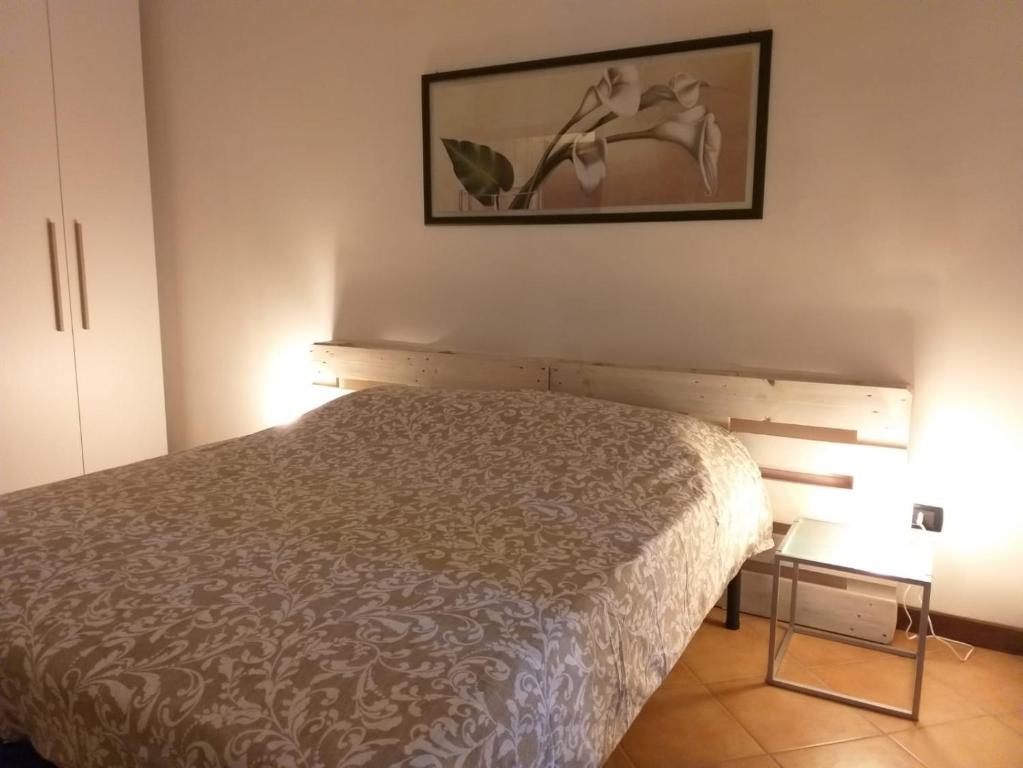 1 dormitorio con 1 cama y una foto en la pared en Casa di Gabry, en Cento
