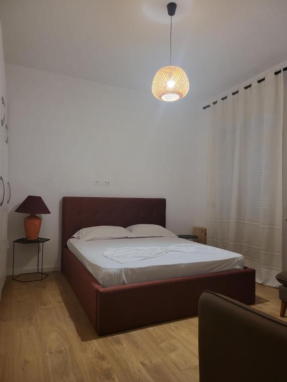 una camera con letto e luce a ciondolo di SKY Apartment a Vlorë