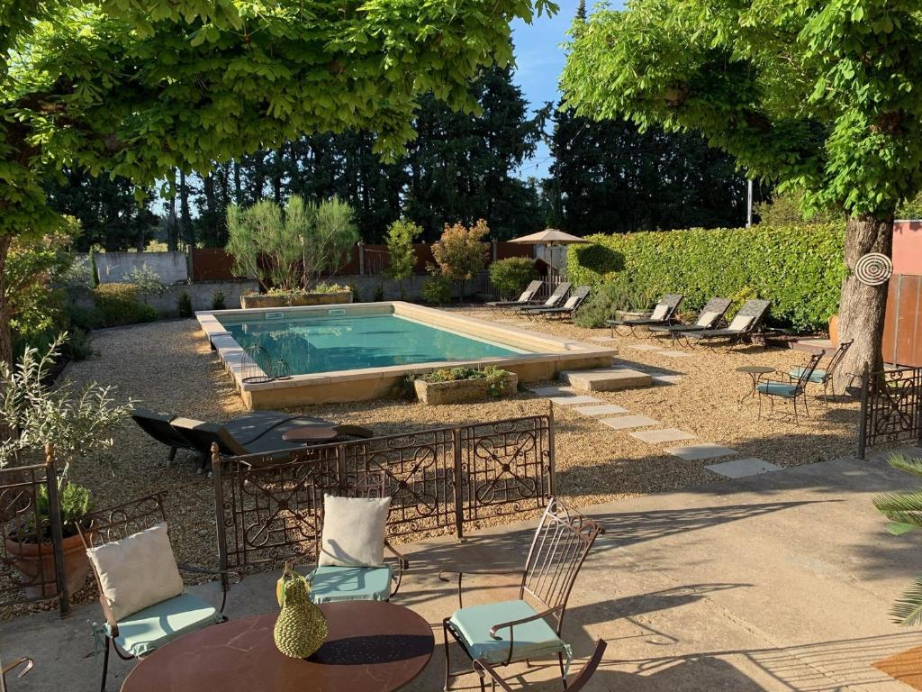 een achtertuin met een zwembad en stoelen en een tafel bij Maison Verquiéres, 5 pièces, 10 personnes - FR-1-599-15 in Verquières