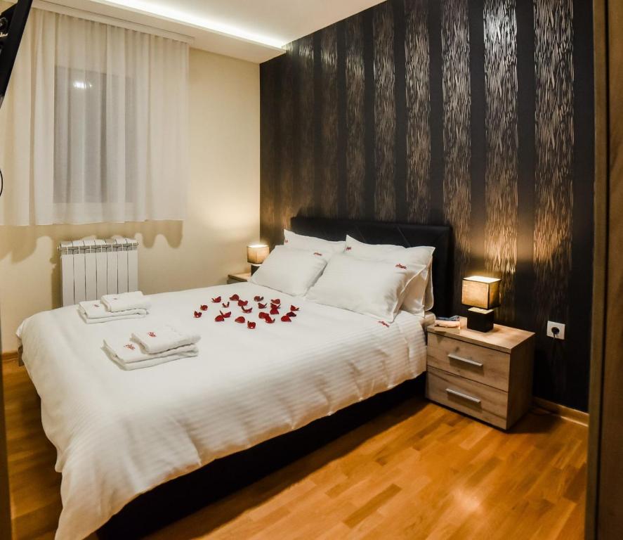 Un dormitorio con una cama con rosas rojas. en Saga apartment Zlatibor, en Zlatibor