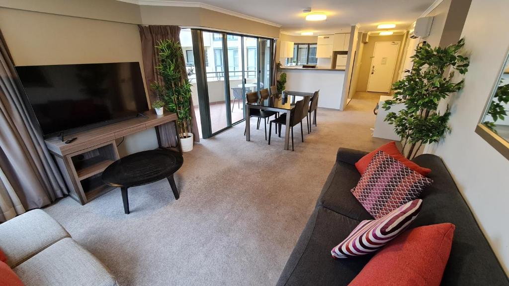 a living room with a couch and a flat screen tv at 2BR 2Bath L4 Executive Apartment, in City Centre in Canberra