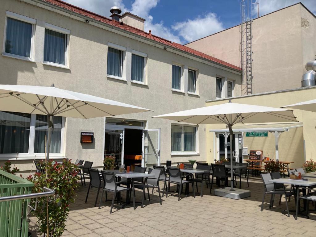 a patio with tables and umbrellas in front of a building at Kolpingsfamilie Poysdorf in Poysdorf