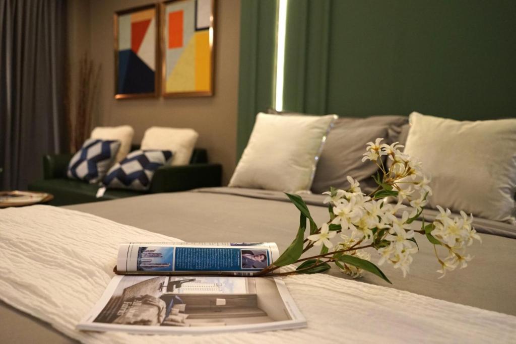 a book on a bed with a vase of flowers on it at The Bed by Boonjira in Chon Buri