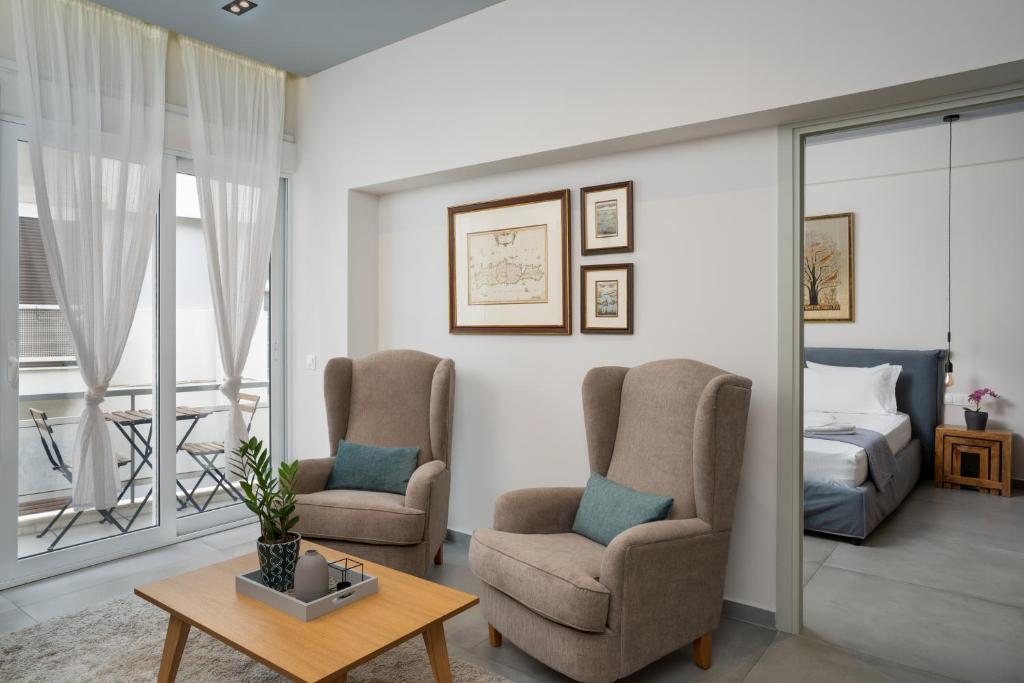 a living room with two chairs and a bed at Crown Designed Apartments in Athens
