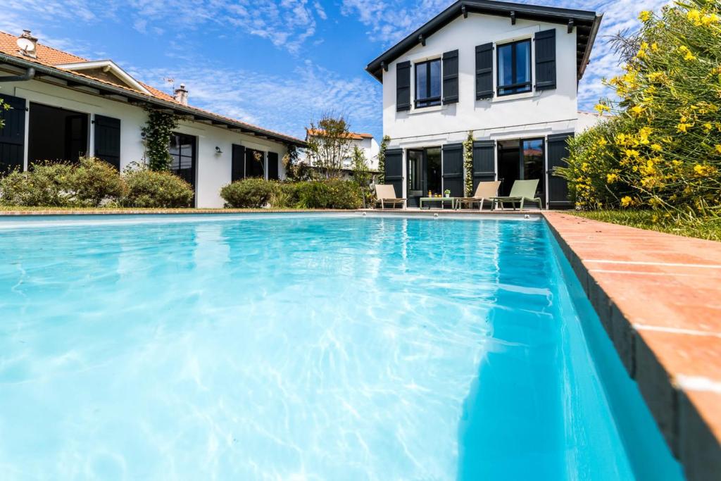 une piscine devant une maison dans l'établissement LEONIE KEYWEEK Villa close to the Lighthouse and Biarritz's Golf course, à Biarritz