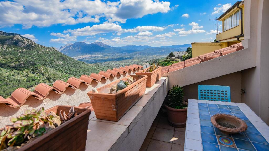 d'un balcon avec des plantes en pot et une vue sur les montagnes. dans l'établissement Welcomely - Casa Ortobene, à Nuoro