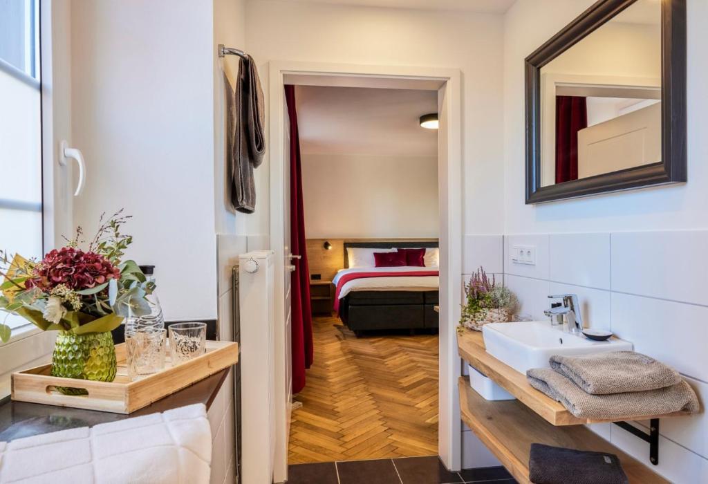 a bathroom with a sink and a room with a bed at Erler Koornhuus in Raesfeld