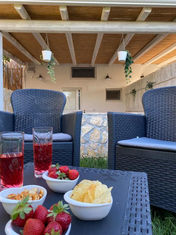 a table with bowls of chips and fruit on a patio at Le Casette tra gli Ulivi in Santa Maria Del Focallo