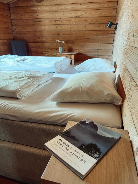 two beds in a room with a book on a table at Åndalsnes Hytteutleie in Åndalsnes