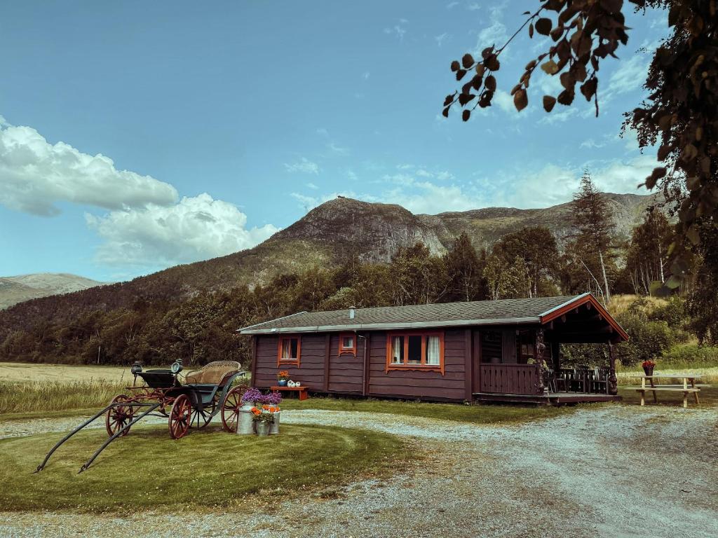 a cabin in a field with a mountain in the background at Åndalsnes Hytteutleie in Åndalsnes