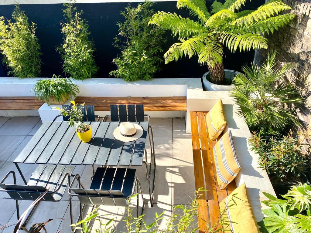 um pátio com uma mesa, cadeiras e plantas em The Keep - a stylish retreat opposite Deal Castle and seconds to the beach em Deal