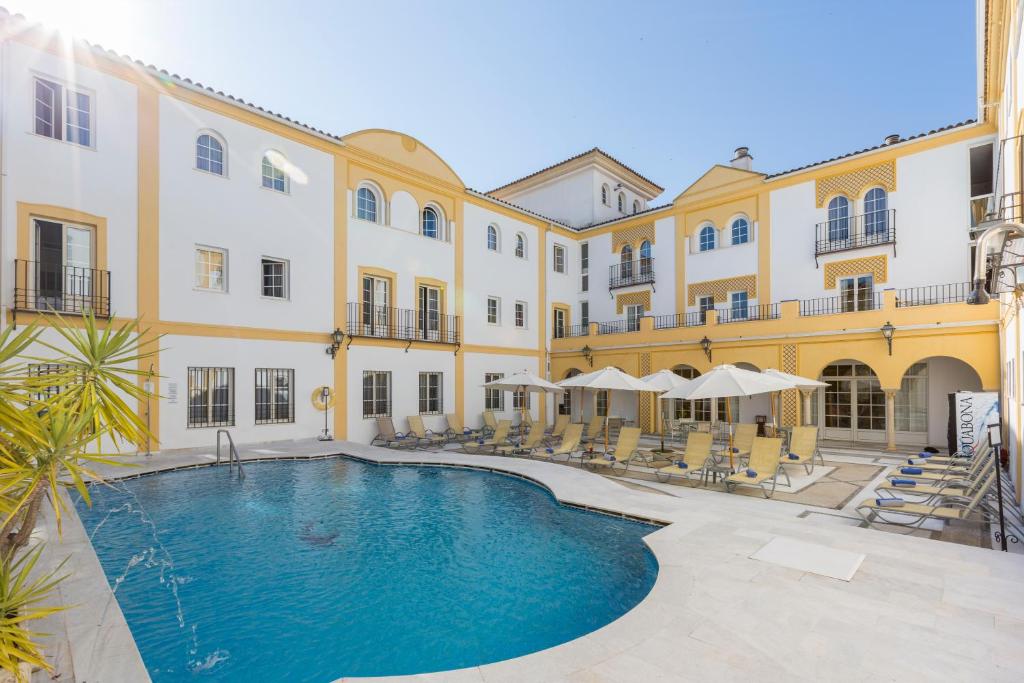 a hotel room with a pool and a balcony at Maciá Alfaros in Córdoba