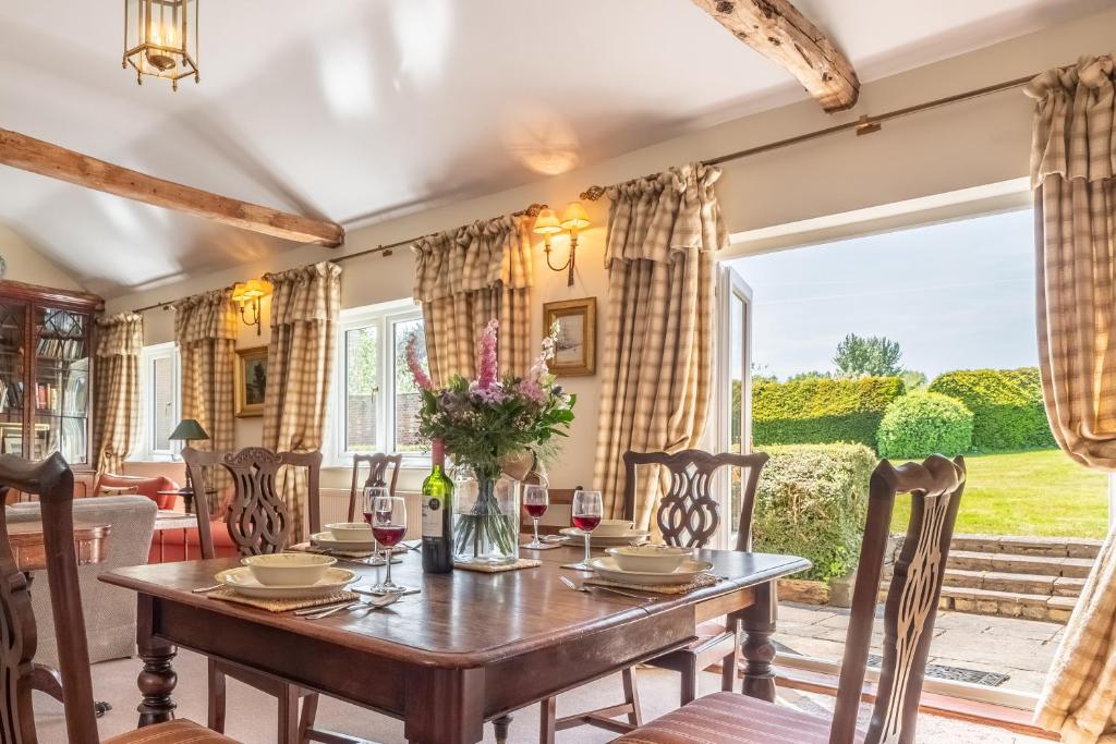 a dining room with a table and chairs and a large window at Charming cottage in beautiful countryside with a boating lake - The Calf Pens in Ipswich