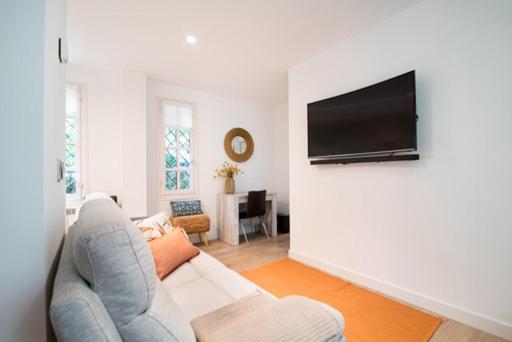 uma sala de estar com um sofá e uma televisão de ecrã plano em La casa de la brujita with AC em San Sebastián