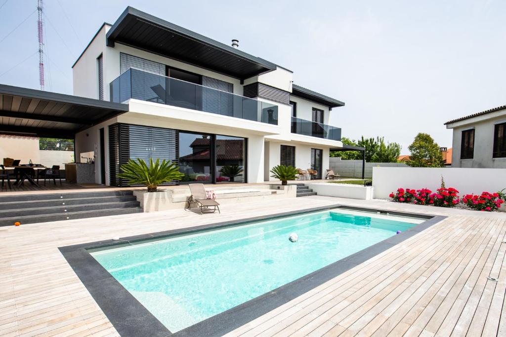 a house with a swimming pool in front of a house at Villa Kraljica in Portorož
