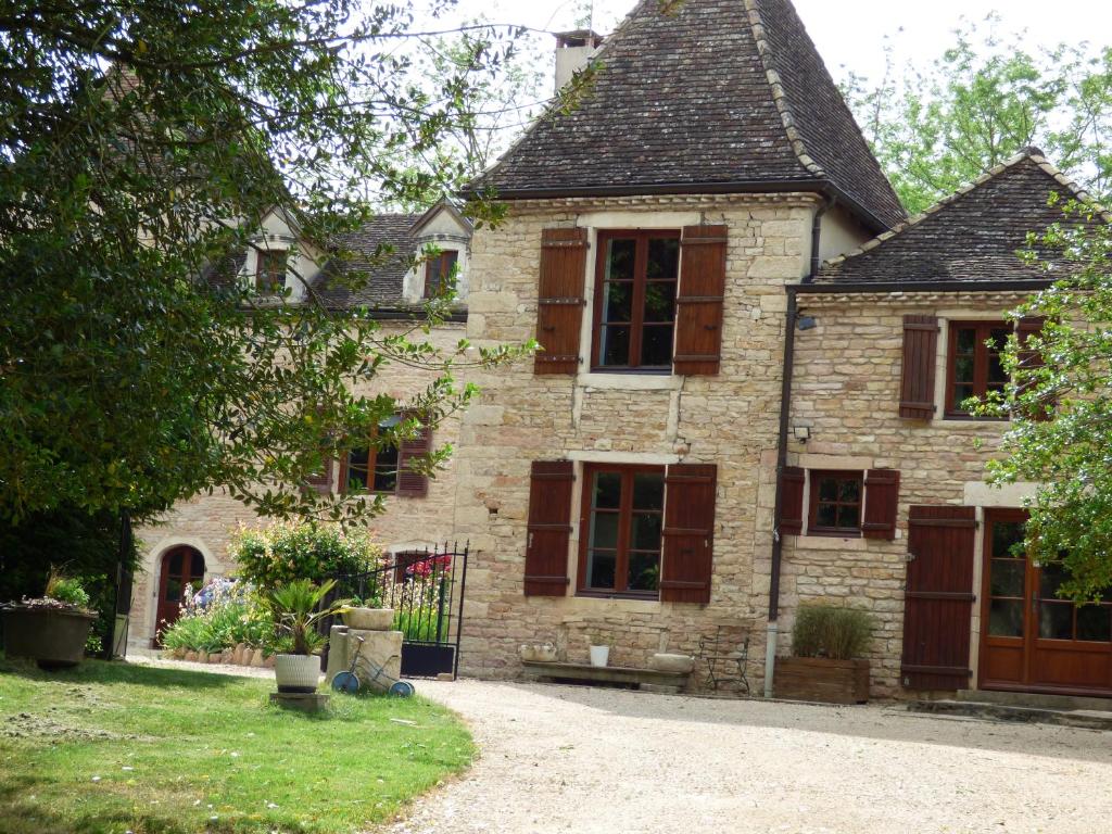 une ancienne maison en pierre avec des fenêtres marron et une allée. dans l'établissement MAISON SYLVAIN, à Tournus